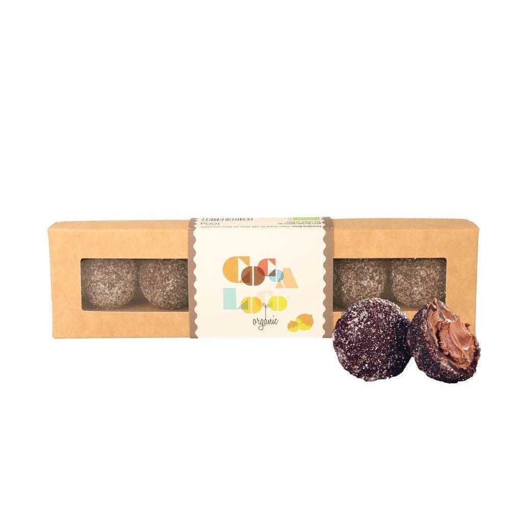 A Cocoa Loco Dark Chocolate Praline Truffles with a truffle outside of the box in half, showing the praline filling.