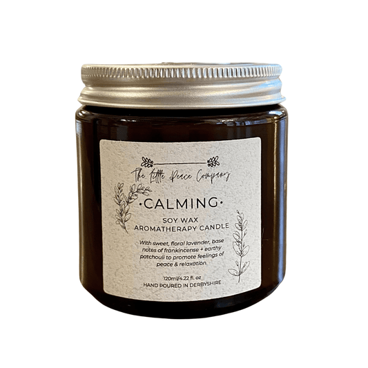 A soy wax calming candle in a brown jar, against a white background.